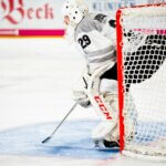 person guarding goalie net in field
